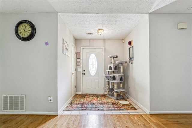 entrance foyer featuring wood finished floors, baseboards, and a textured ceiling
