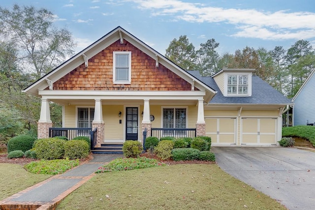 craftsman inspired home featuring a garage, covered porch, and a front yard