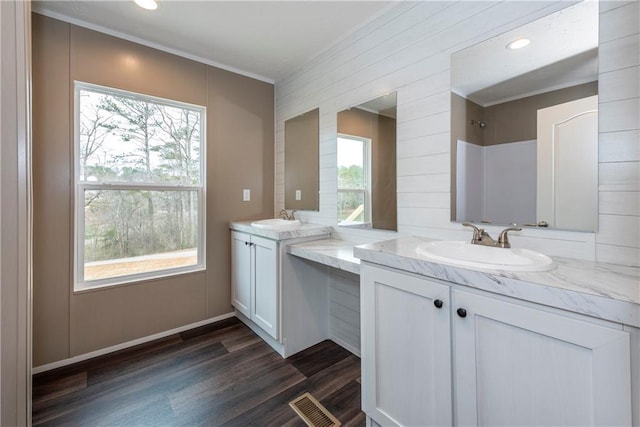 bathroom with two vanities, a sink, and wood finished floors