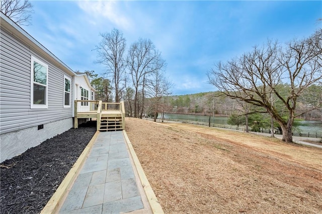 view of yard with a deck with water view