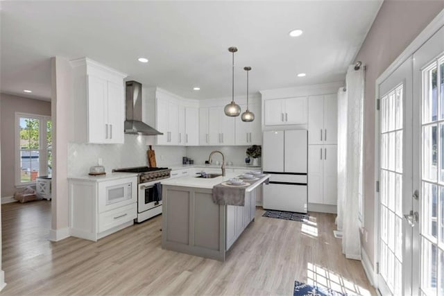 829 Verdun Way, Marietta, GA 30064 - kitchen featuring wall chimney range hood, light wood-style floors, white appliances, light countertops, and white cabinets