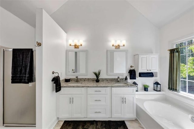 829 Verdun Way, Marietta, GA 30064 - bathroom featuring a bath, vaulted ceiling, a sink, and double vanity