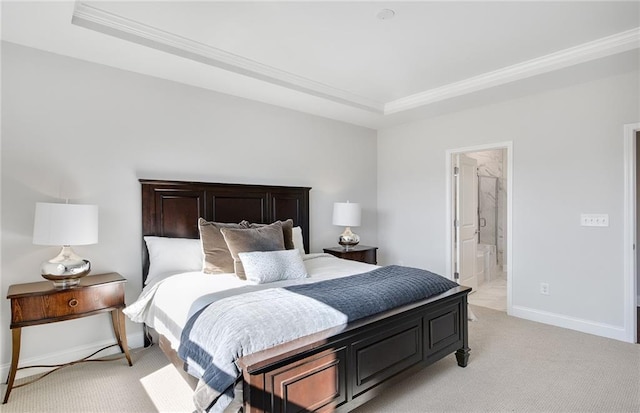 bedroom featuring light carpet, crown molding, a tray ceiling, and ensuite bath