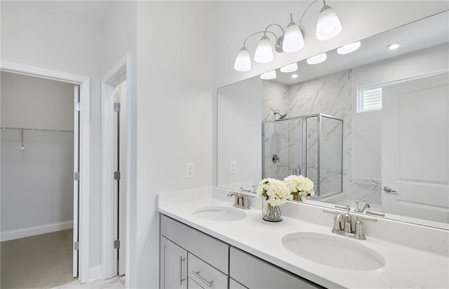 bathroom featuring a shower with shower door and vanity