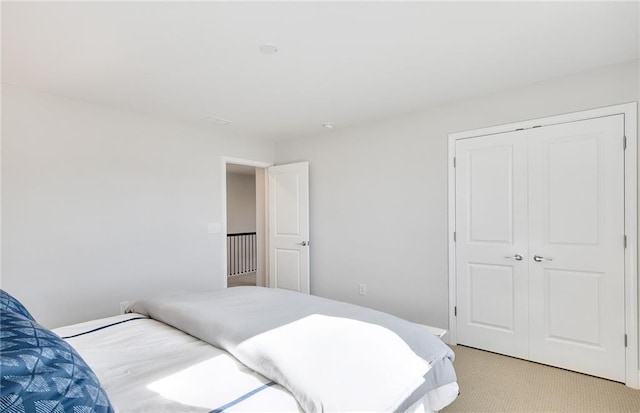 bedroom featuring light colored carpet and a closet