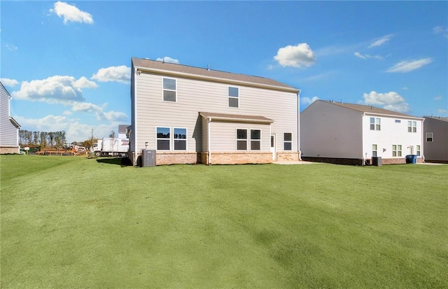 rear view of property featuring central AC unit and a yard