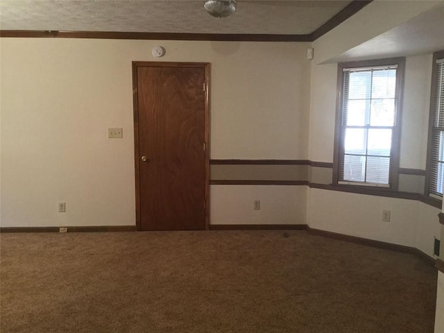 spare room with dark carpet and crown molding