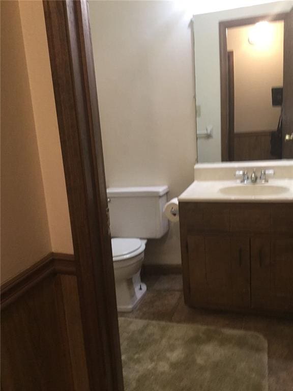 bathroom with tile patterned flooring, vanity, and toilet