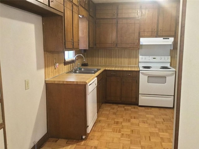 kitchen with decorative backsplash, white appliances, light parquet floors, and sink