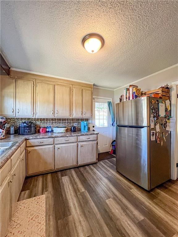 kitchen with backsplash, dark wood-type flooring, stainless steel refrigerator, and light brown cabinets