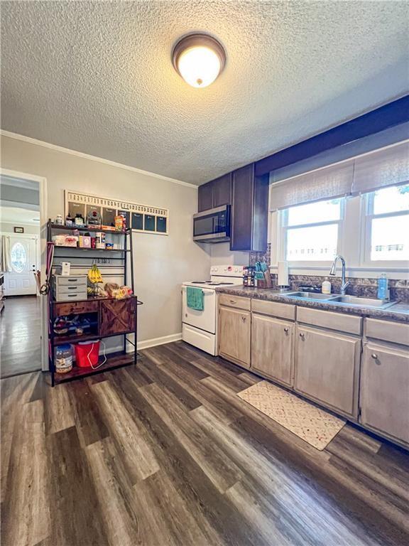 kitchen with sink, a textured ceiling, electric range, and dark hardwood / wood-style floors