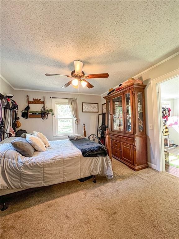 carpeted bedroom featuring crown molding, a textured ceiling, and ceiling fan