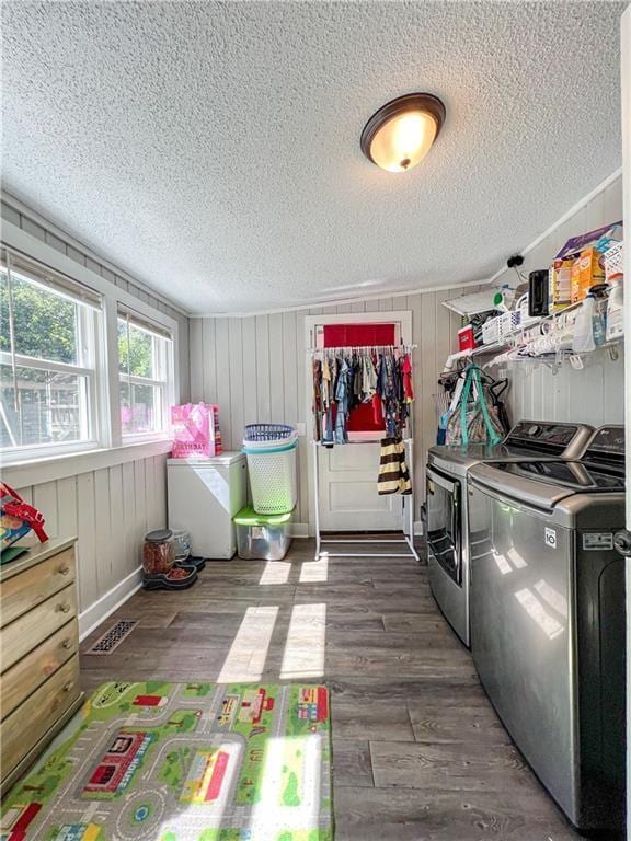 laundry room featuring washing machine and dryer, dark wood-type flooring, and a textured ceiling