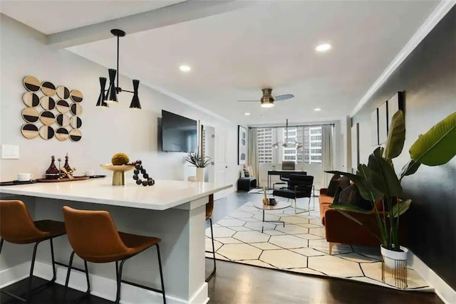 interior space featuring pendant lighting, ceiling fan, a breakfast bar, and kitchen peninsula