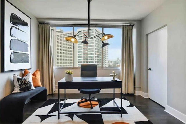 office space featuring dark wood-type flooring and a chandelier