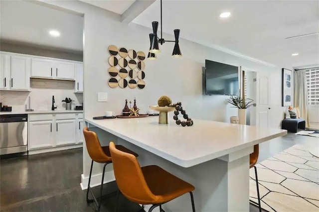 kitchen featuring a breakfast bar area, white cabinetry, decorative light fixtures, dishwasher, and decorative backsplash