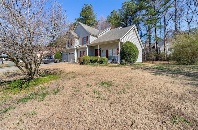 view of side of home featuring a garage, driveway, and a lawn