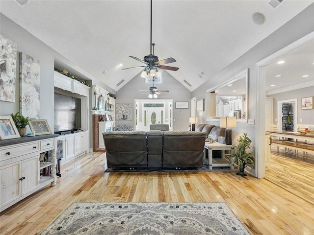 living room with ceiling fan, light wood-type flooring, and high vaulted ceiling