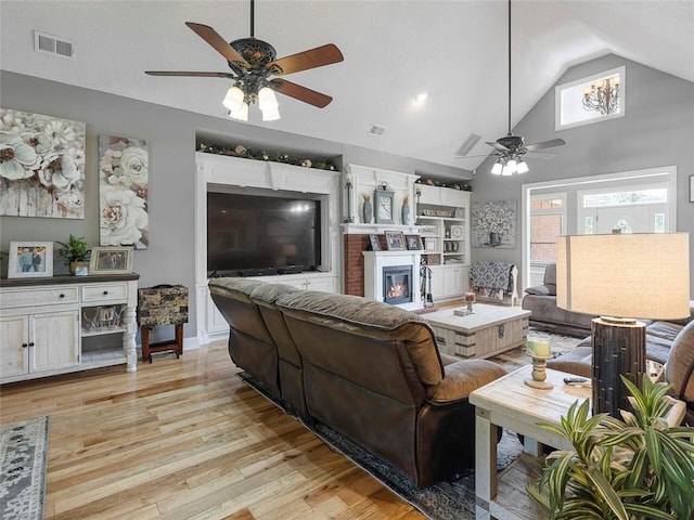 living room with ceiling fan, light hardwood / wood-style flooring, and high vaulted ceiling