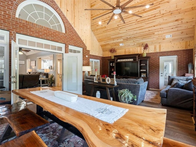 dining area featuring brick wall, ceiling fan, dark hardwood / wood-style flooring, wooden ceiling, and high vaulted ceiling