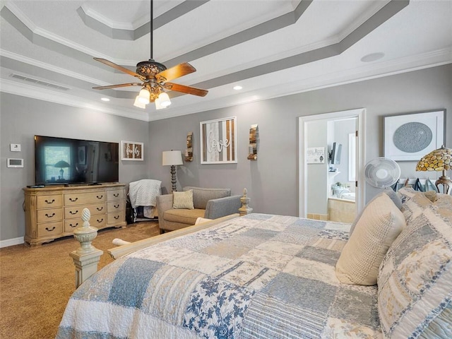 carpeted bedroom with crown molding, a tray ceiling, ceiling fan, and ensuite bathroom