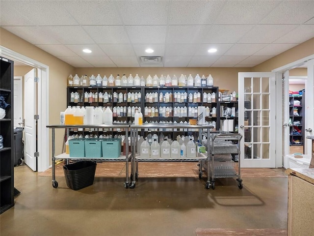 bar with concrete flooring and a drop ceiling