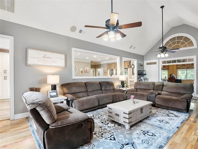 living room with light hardwood / wood-style flooring, ceiling fan, and high vaulted ceiling