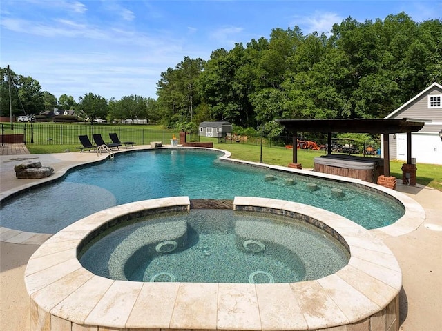 view of pool with a lawn, an in ground hot tub, and an outdoor structure