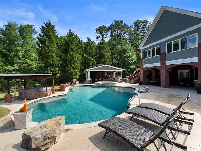 view of pool with a patio area and an outdoor hot tub