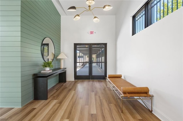 entryway with light hardwood / wood-style flooring, french doors, and a high ceiling