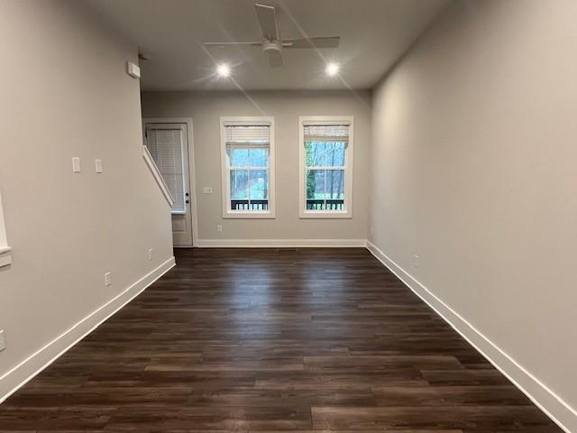 unfurnished room featuring dark wood-type flooring and ceiling fan