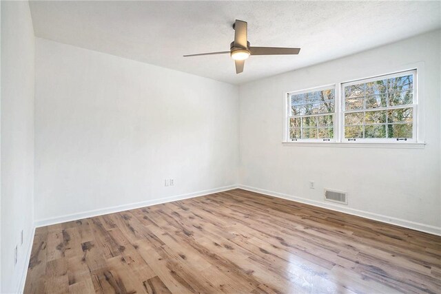 empty room with ceiling fan and wood-type flooring