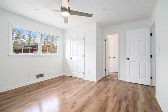 unfurnished bedroom featuring ceiling fan, a closet, and light hardwood / wood-style flooring