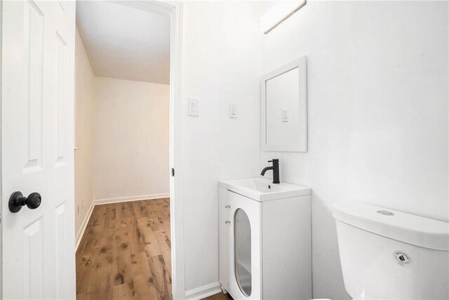 bathroom with hardwood / wood-style flooring, toilet, and sink