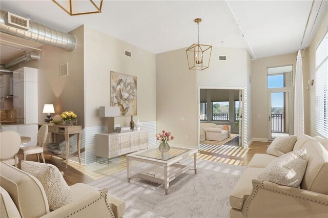 3820 Roswell Rd NE Unit 317, Atlanta, GA 30342 - kitchen with visible vents, light wood-style flooring, a peninsula, appliances with stainless steel finishes, and wall chimney exhaust hood