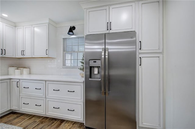 kitchen featuring white cabinetry, backsplash, stainless steel fridge, and dark wood-type flooring