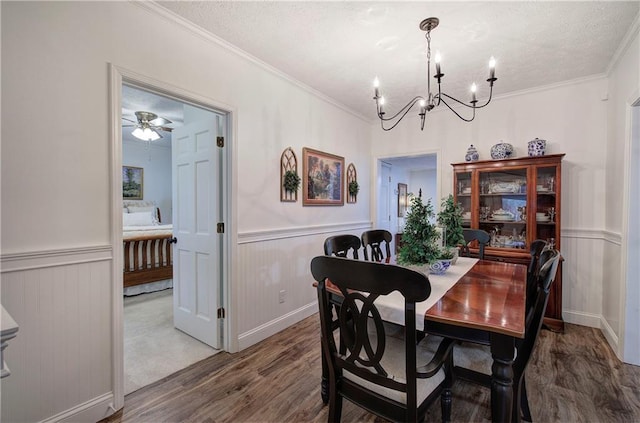 dining room with hardwood / wood-style flooring, ceiling fan with notable chandelier, crown molding, and a textured ceiling