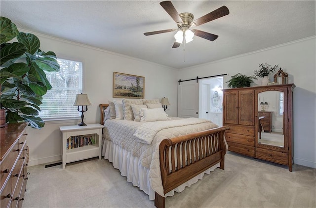 bedroom with ceiling fan, a barn door, ornamental molding, a textured ceiling, and light colored carpet