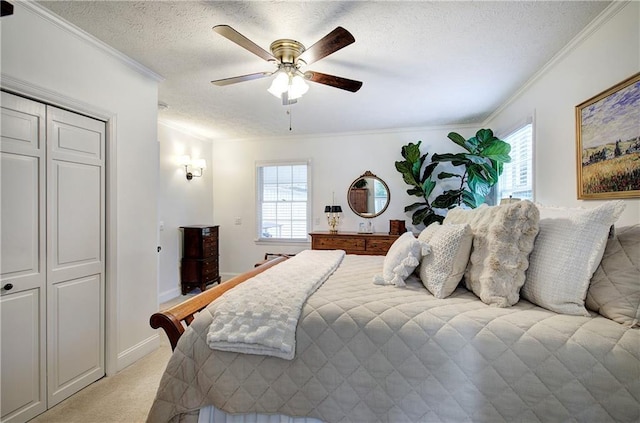 bedroom featuring ceiling fan, a closet, light colored carpet, and ornamental molding