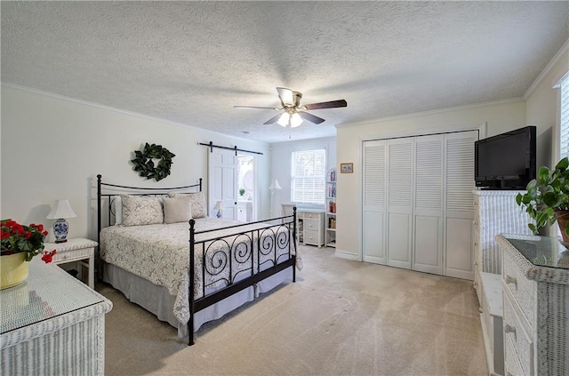 bedroom featuring ceiling fan, a barn door, crown molding, and light carpet