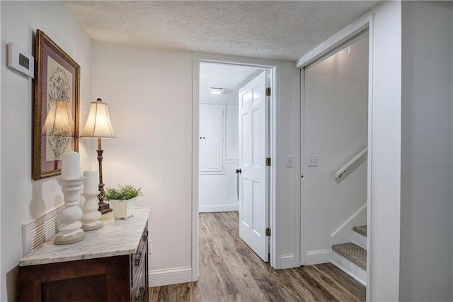 hallway featuring wood-type flooring and a textured ceiling