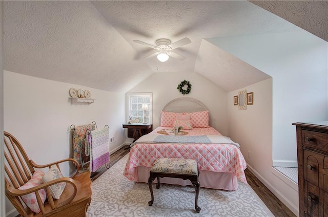 bedroom with a textured ceiling, ceiling fan, vaulted ceiling, and hardwood / wood-style flooring