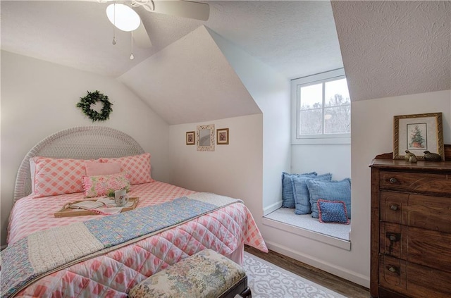 bedroom featuring ceiling fan, wood-type flooring, a textured ceiling, and vaulted ceiling