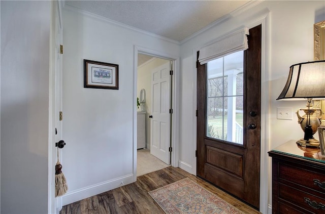 entryway with ornamental molding, a textured ceiling, and light wood-type flooring