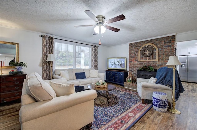 living room featuring ceiling fan, ornamental molding, a textured ceiling, and hardwood / wood-style flooring