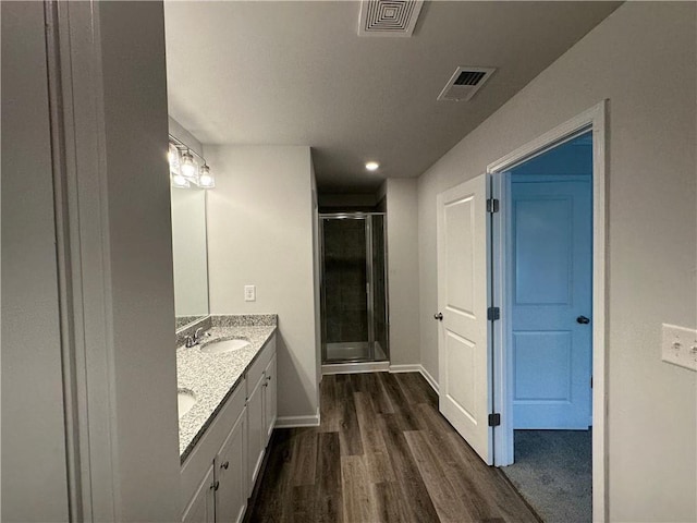 bathroom with vanity, an enclosed shower, and wood-type flooring