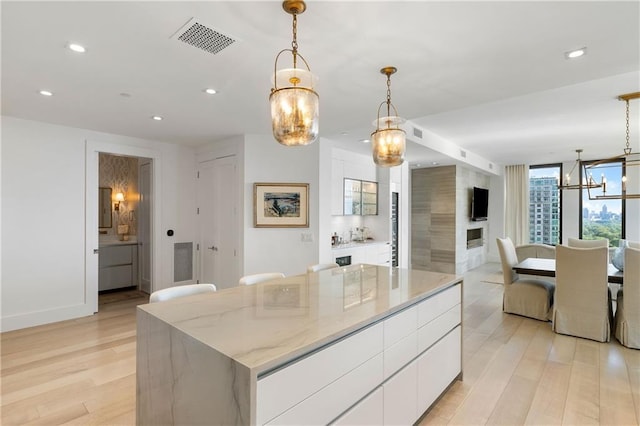 3107 Peachtree Rd NE Unit 1403, Atlanta, GA 30305 - kitchen with visible vents, white cabinets, a notable chandelier, recessed lighting, and light wood-style flooring