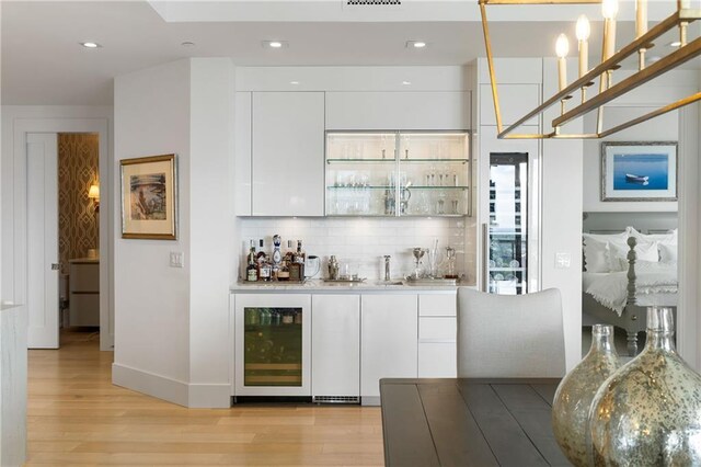 3107 Peachtree Rd NE Unit 1403, Atlanta, GA 30305 - bar featuring tasteful backsplash, baseboards, indoor wet bar, light wood-style flooring, and beverage cooler