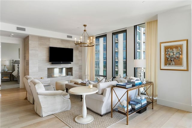 3107 Peachtree Rd NE Unit 1403, Atlanta, GA 30305 - living room with light wood-style floors, visible vents, an inviting chandelier, and a wall of windows