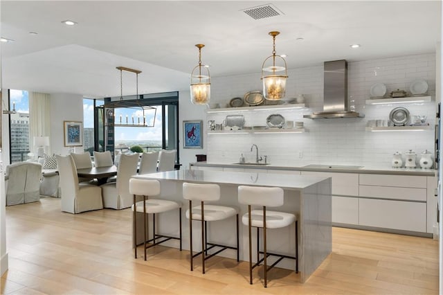 3107 Peachtree Rd NE Unit 1403, Atlanta, GA 30305 - kitchen with open shelves, wall chimney range hood, black electric cooktop, and visible vents